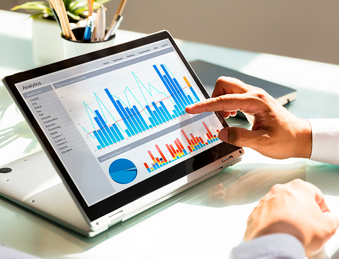 Hands using a tablet that has graphs on